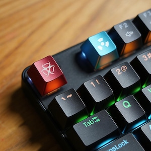 May include: Close-up of a mechanical keyboard with custom keycaps. The keycaps are black, with some keys in red and blue. The red keycap has a biohazard symbol, and the blue keycap has a radiation symbol.