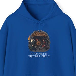 May include: A blue hoodie with a graphic of three figures entering a cave with a sign that reads "The Legendary Cave of Curiosity!" and the text "If you prep it, they will skip it."