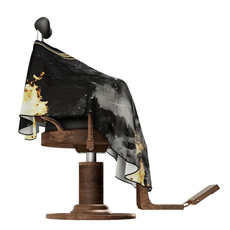 May include: A barber's chair with a black and gold patterned cape. The chair has a wooden base and a footrest.