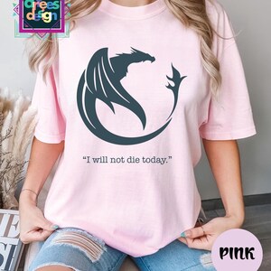 a woman wearing a pink shirt with a dragon on it