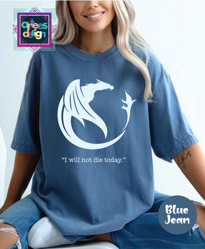 a woman wearing a blue t - shirt with a white dragon on it