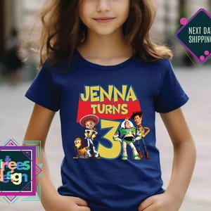 a young girl wearing a t - shirt with a picture of the characters from the