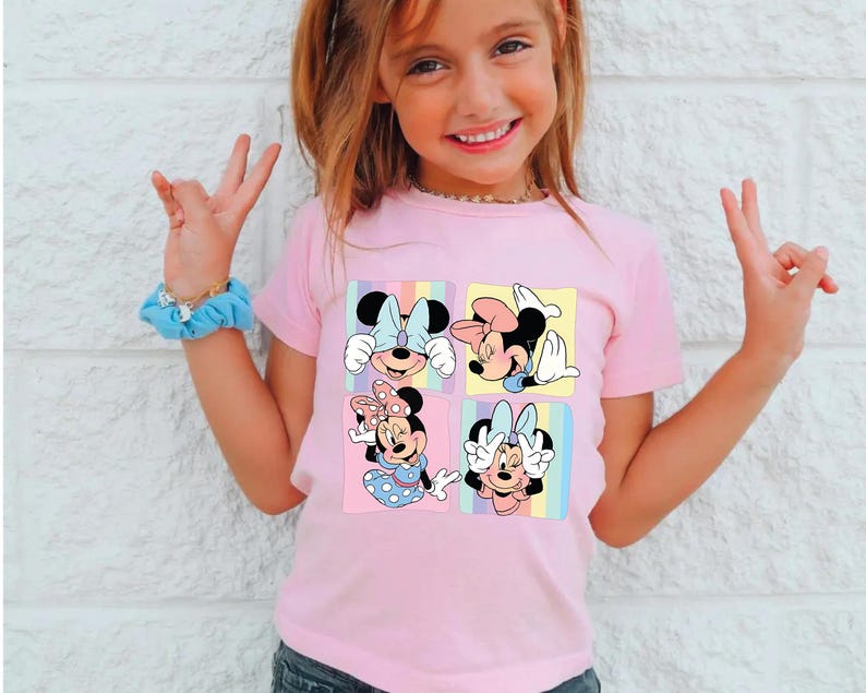 a little girl wearing a pink shirt with mickey mouse on it