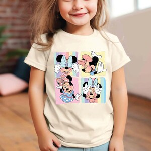 a little girl wearing a mickey mouse t - shirt