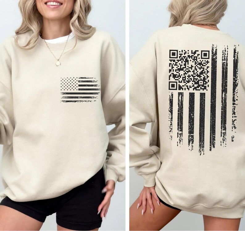 A woman wearing a beige sweatshirt with an American flag design and a QR code on the back.