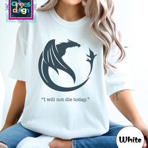 a woman wearing a white t - shirt with a black dragon on it