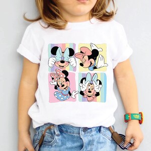 a little girl wearing a mickey mouse shirt