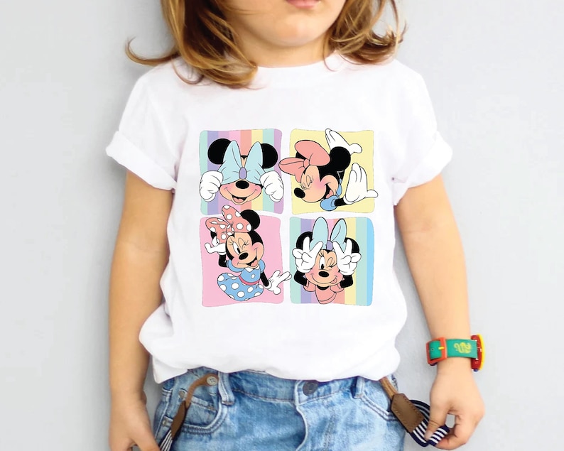 a little girl wearing a mickey mouse shirt