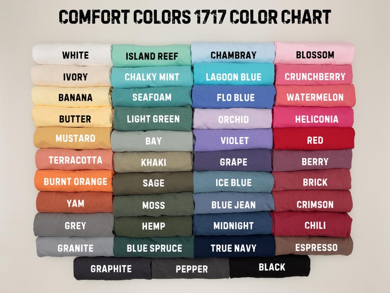 May include: A color chart titled "COMFORT COLORS 1717 COLOR CHART" displays a variety of folded fabric samples. Colors include white, ivory, banana, butter, mustard, terracotta, burnt orange, yam, grey, granite, island reef, chalky mint, seafoam, light green, bay, khaki, sage, moss, hemp, blue spruce, chambray, lagoon blue, flo blue, orchid, violet, grape, ice blue, blue jean, midnight, true navy, blossom, crunchberry, watermelon, heliconia, red, berry, brick, crimson, chili, and espresso.