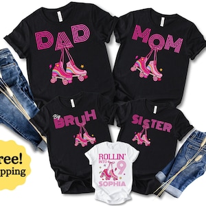 May include: Black t-shirts with pink text and roller skate graphics. The shirts say "DAD", "MOM", "Big Bruh", and "Sister". A white shirt says "ROLLIN' INTO 9 SOPHIA". Blue jeans and a "Free! Shipping" sticker are also in the image.