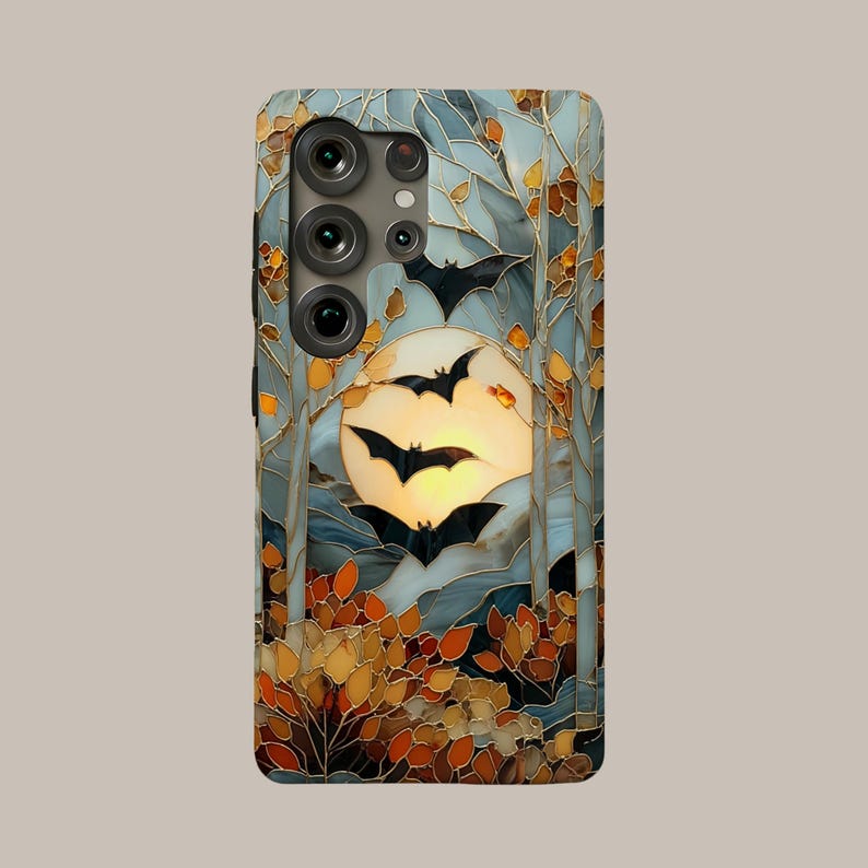 May include: A rectangular smartphone case featuring a stained glass style design of a full moon in a pale yellow sky, surrounded by tall trees and autumn foliage in shades of orange and brown, with several black bat silhouettes flying.
