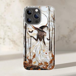 May include: A phone case with a witch design, wearing a white dress and black hat, set in a forest with a full moon. The artwork includes bats, autumn leaves, and bare trees, perfect for Halloween.
