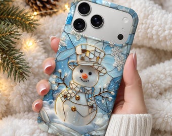 May include: A smartphone case featuring a stained-glass style design of a snowman wearing a top hat. The background is a light blue mosaic pattern with white snowflakes. The snowman has a bright orange carrot nose and dark buttons.