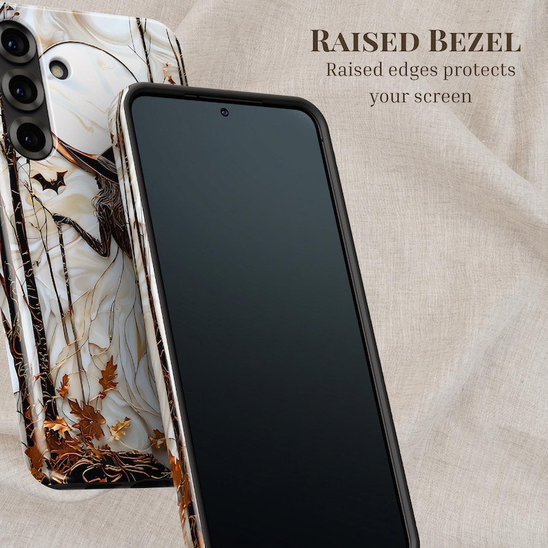May include: A smartphone with a black screen and a protective case. The case has a white and brown marble design with a bat and autumn leaves. The text "RAISED BEZEL" is visible, along with the phrase "Raised edges protects your screen."