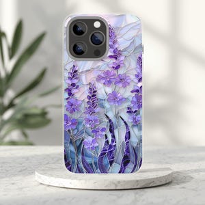 May include: A phone case with a stained-glass effect, depicting lavender flowers in purple, blue, and white. The case has a clear border and a multi-lens camera cutout.