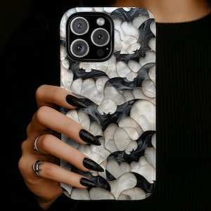 May include: A smartphone case featuring a repeating pattern of stylized black and white bats. The design has a glossy, pearlescent finish with overlapping shapes that create a layered effect across the entire surface of the rectangular phone cover.