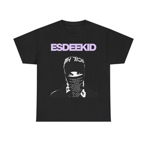 Könnte beinhalten: Schwarzes T-Shirt mit dem Wort "ESDEEKID" in hellvioletter Schrift oben. Darunter befindet sich eine Schwarz-Weiß-Grafik einer Person mit Gesichtsbedeckung und Text.