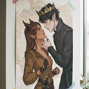 May include: Art print of a couple in a fantasy setting. The woman has brown hair and horns, wearing a green dress and gloves. The man wears a crown and black attire. The artwork is attached to a white wall with tape.