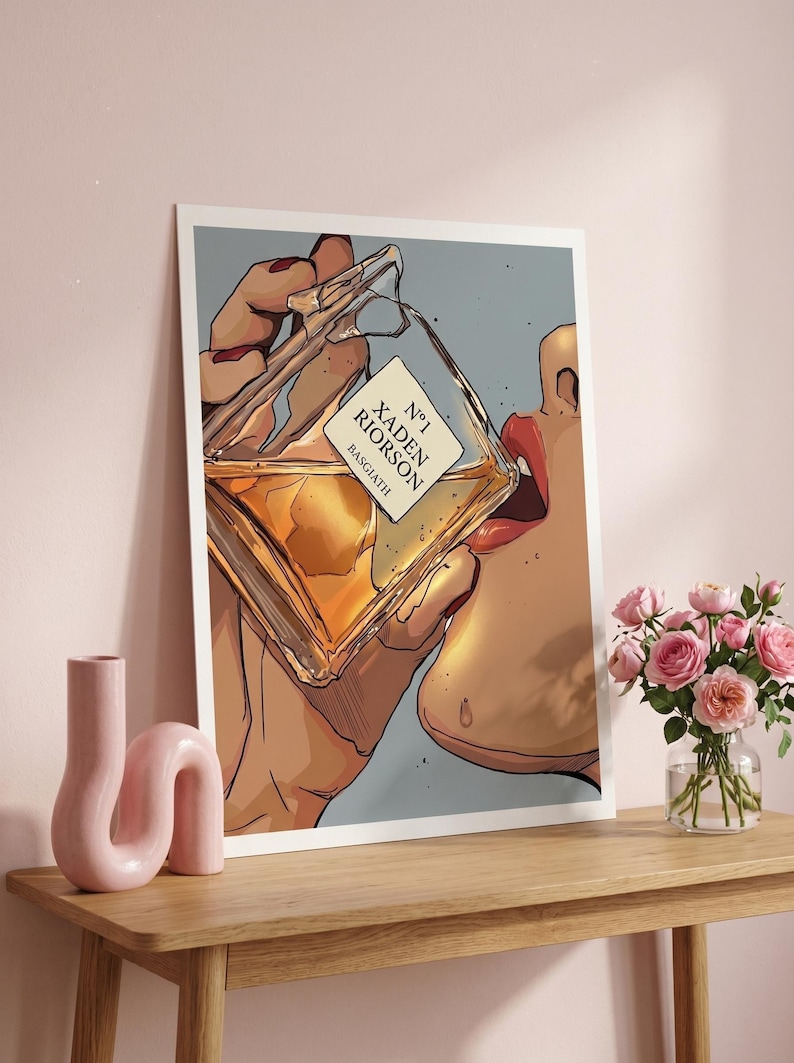 Pode incluir: Ilustra&ccedil;&atilde;o de uma pessoa bebendo de um frasco de perfume. O frasco est&aacute; rotulado como "N&deg;1 Xaden Riorson Basgiath". A obra de arte tem uma paleta de cores suaves com um fundo claro. Um vaso de rosas cor-de-rosa est&aacute; sobre uma mesa de madeira.