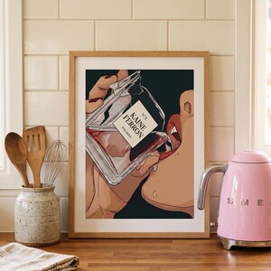 May include: Framed art print featuring a stylized illustration of a person drinking from a perfume bottle. The bottle is labeled "KAINE FERRON PALADIA N&deg;3". The artwork has a dark background and is set in a kitchen with a pink kettle.