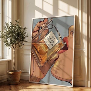 Pode incluir: Ilustra&ccedil;&atilde;o de uma pessoa bebendo de um frasco de perfume. O frasco est&aacute; rotulado como "N&deg;1 Xaden Riorson Basgiath". A obra de arte &eacute; emoldurada em branco, com um fundo azul claro. A imagem est&aacute; em uma sala com uma planta em vaso e piso de madeira.