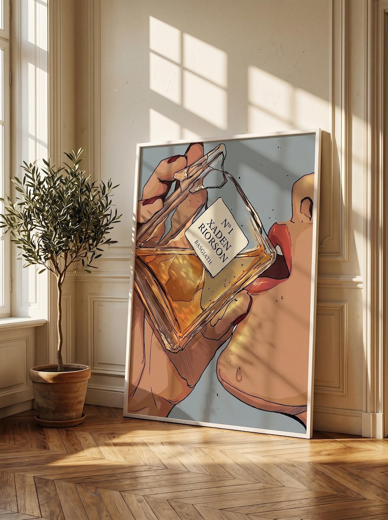 Pode incluir: Ilustra&ccedil;&atilde;o de uma pessoa bebendo de um frasco de perfume. O frasco est&aacute; rotulado como "N&deg;1 Xaden Riorson Basgiath". A obra de arte &eacute; emoldurada em branco, com um fundo azul claro. A imagem est&aacute; em uma sala com uma planta em vaso e piso de madeira.