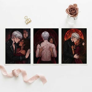 May include: Three art prints with romantic illustrations. Each print shows a couple in a passionate embrace, with one showing a man's back covered in markings. The colour palette includes deep reds, blacks, and whites, creating a dramatic and intimate feel.