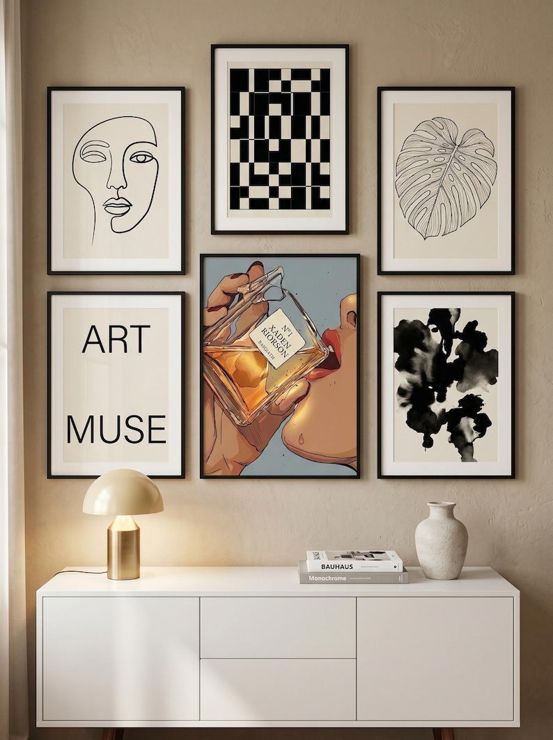 Pode incluir: Uma cole&ccedil;&atilde;o de impress&otilde;es de arte emolduradas com designs e ilustra&ccedil;&otilde;es abstratas. As impress&otilde;es incluem um desenho de linha de um rosto, um padr&atilde;o geom&eacute;trico em preto e branco, uma folha e uma imagem gr&aacute;fica de uma pessoa bebendo de um frasco de perfume. A palavra "ART MUSE" tamb&eacute;m &eacute; exibida.