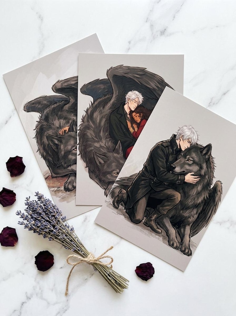 May include: Three art prints featuring illustrations of a wolf with feathered wings, and a person with white hair. One print shows a person embracing the wolf. The prints are on a light gray background. Dried lavender and rose petals are scattered around the prints.