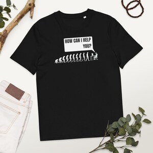 Könnte beinhalten: Schwarzes T-Shirt mit einer weißen Grafik einer Strichmännchen-Evolution, die zu einer Person führt, die an einem Computer sitzt, mit einer Sprechblase über dem Kopf, die "HOW CAN I HELP YOU?" sagt.