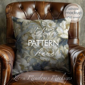May include: A white and gold floral patterned pillow on a brown leather armchair. The pillow has the text "Your Pattern Here" on it.