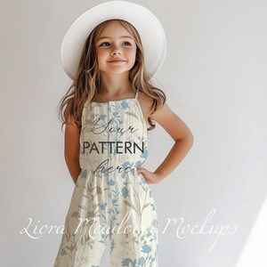 K&ouml;nnte beinhalten: Ein junges M&auml;dchen tr&auml;gt einen wei&szlig;en Sonnenhut und einen hellgelben Overall mit blauem Blumenmuster. Der Overall hat einen Knopfverschluss und d&uuml;nne Tr&auml;ger. Der Text "Your Pattern Here" ist auf der Vorderseite des Overalls aufgedruckt.