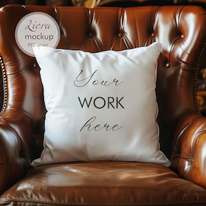 May include: White pillow with the text "Your work here" on a brown leather armchair.