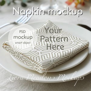 May include: A folded white napkin with a geometric pattern, placed on a white plate. The napkin is part of a mockup, with text overlaying the image that reads "Napkin mockup", "PSD mockup smart object", and "Your Pattern Here".