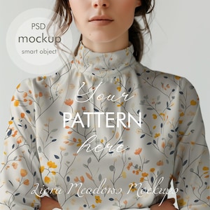 Puede incluir: Una blusa blanca de cuello alto con un estampado floral en tonos amarillos, naranjas y grises. El texto "Your Pattern Here" está superpuesto en la blusa.