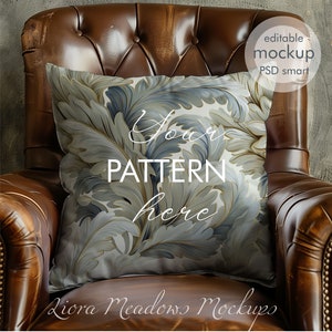 May include: A white pillow with a blue and gold floral pattern sits on a brown leather armchair. The pillow has the text "Your Pattern Here" on it.