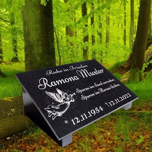 Könnte beinhalten: Schwarzer Granit-Grabstein mit einem weißen Engel und der Inschrift "Ruhe in Frieden Ramona Muster Spuren im Sand verwehen, Spuren im Herzen bleiben. * 12.11.1954 †12.11.2022"