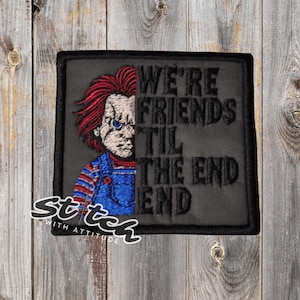 May include: Embroidered patch featuring a half-face image of a doll with red hair and blue overalls. The patch reads "WE'RE FRIENDS TIL THE END" in black text. The patch is black with a black border and the words "Stitch with Attitude" in white.