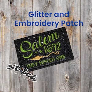 May include: Black glitter and embroidered patch with the text "Salem *1692 THEY MISSED ONE" in green and gold. The patch is rectangular and has a black border. The words "Glitter and Embroidery Patch" are above the patch.