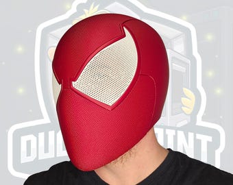 May include: A red and white Spider-Man mask with a textured surface. The mask features large white eye openings with a mesh design. The mask is a full head covering, with a black shirt visible below.