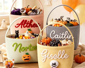 Może przedstawiać: Cztery materiałowe koszyki na Halloween z uchwytami, każdy spersonalizowany wyhaftowanymi imionami: Althea, Norton, Caitlin i Giselle. Koszyki wypełnione są miniaturowymi dyniami, cukierkami kukurydzianymi oraz małymi figurkami duchów i nietoperzy.