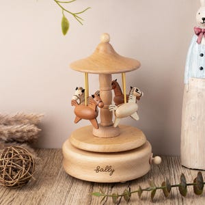 May include: Wooden carousel music box with four horses, a brown roof, and a personalized nameplate that reads "Sally".