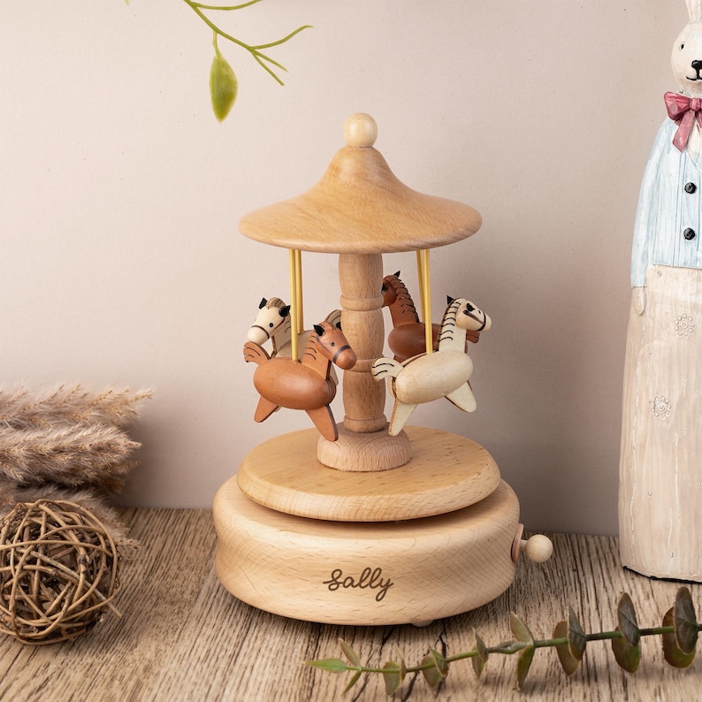May include: Wooden carousel music box with four horses, a brown roof, and a personalized nameplate that reads "Sally".