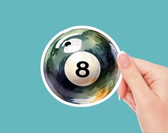 May include: A watercolor-style illustration of a green and black eight ball with a white number eight on it. The ball is surrounded by a white border.