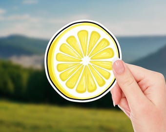 May include: A yellow lemon slice sticker with a white background and a black outline.