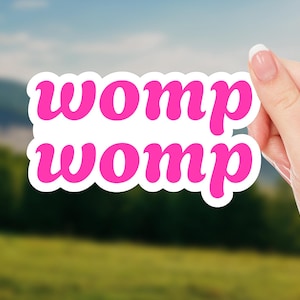 May include: A pink sticker with the word "womp" written twice in a cursive font.