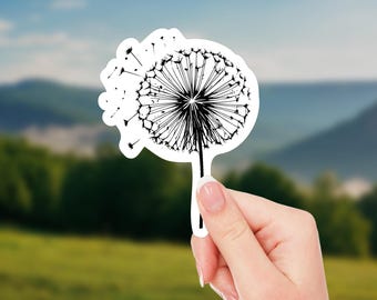May include: A black and white sticker of a dandelion with seeds blowing in the wind.