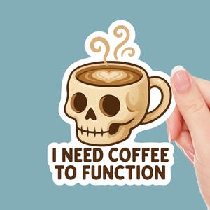 May include: A sticker featuring a skull-shaped coffee cup with steam and a heart-shaped design in the coffee. The text "I NEED COFFEE TO FUNCTION" is below the cup. The sticker is held against a light blue background.