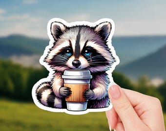 May include: A cartoon raccoon with blue eyes and a sad expression is holding a brown and white to-go coffee cup. The raccoon is sitting on a white background.