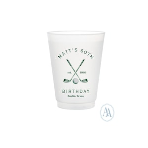 Puede incluir: Un vaso de plástico blanco con un diseño verde con temática de golf. El diseño incluye palos de golf cruzados, una pelota de golf y el texto "Matt's 60th Birthday, est. 1966, Austin, Texas."